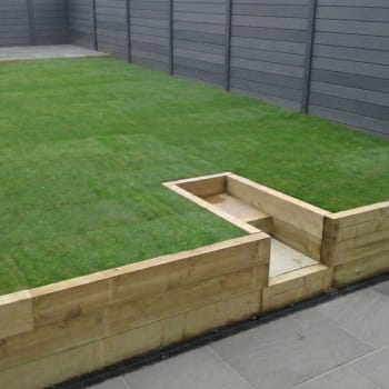 green treated garden railway sleeper retaining wall