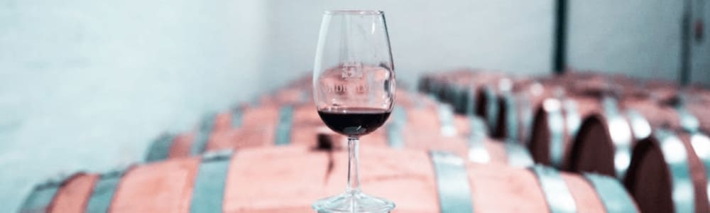 Bilde av et vinglass på toppen av en vintønne.