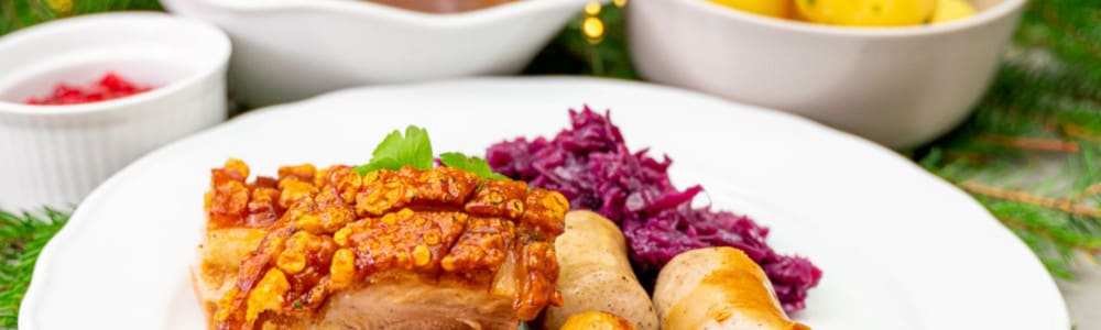 Bilde av en tradisjonell julemiddag med ribbe og tilbehør.