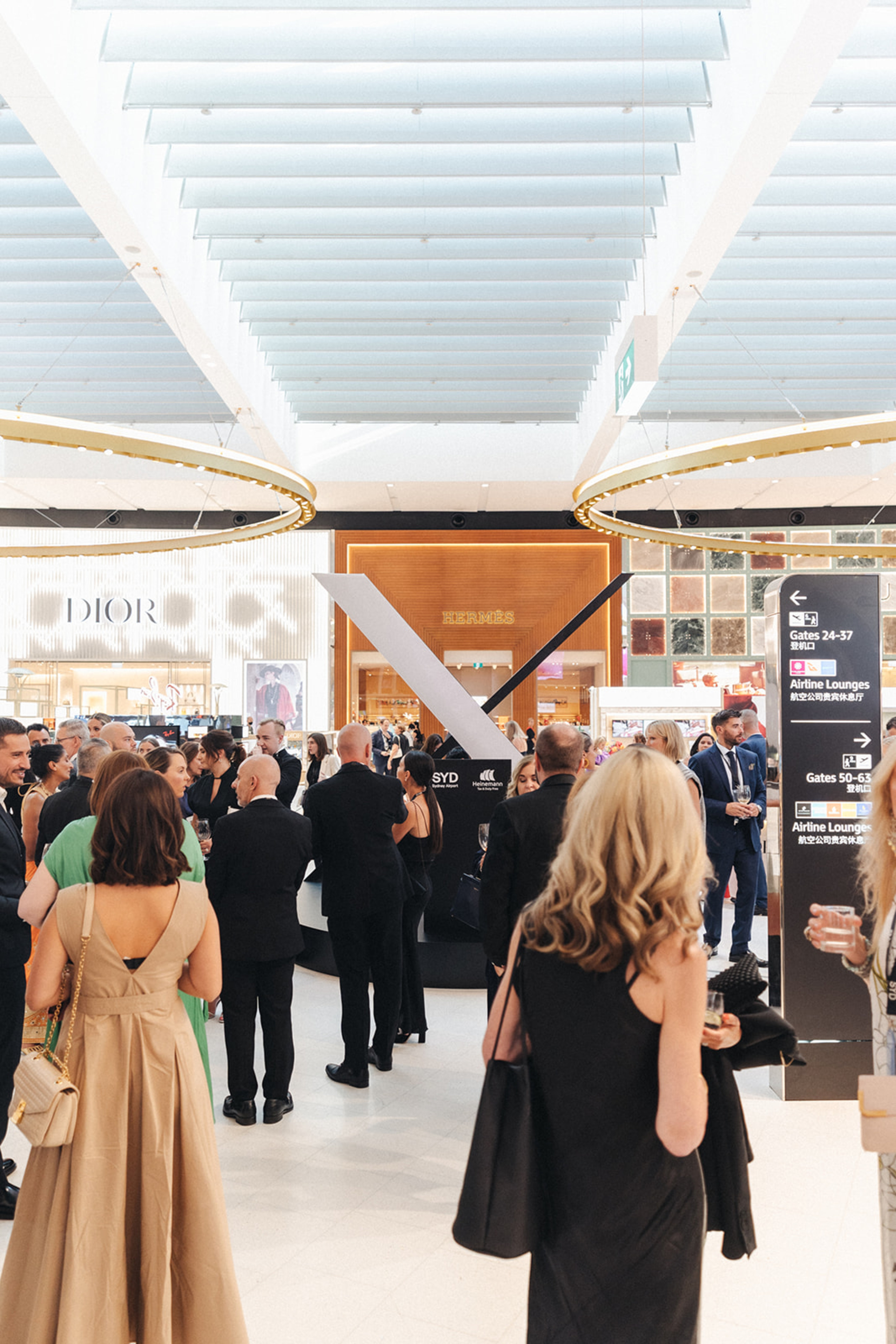 Guests standing in the Heinemann Sydney Airport Luxury Precinct Launch event, produced by MAXCo.LAB