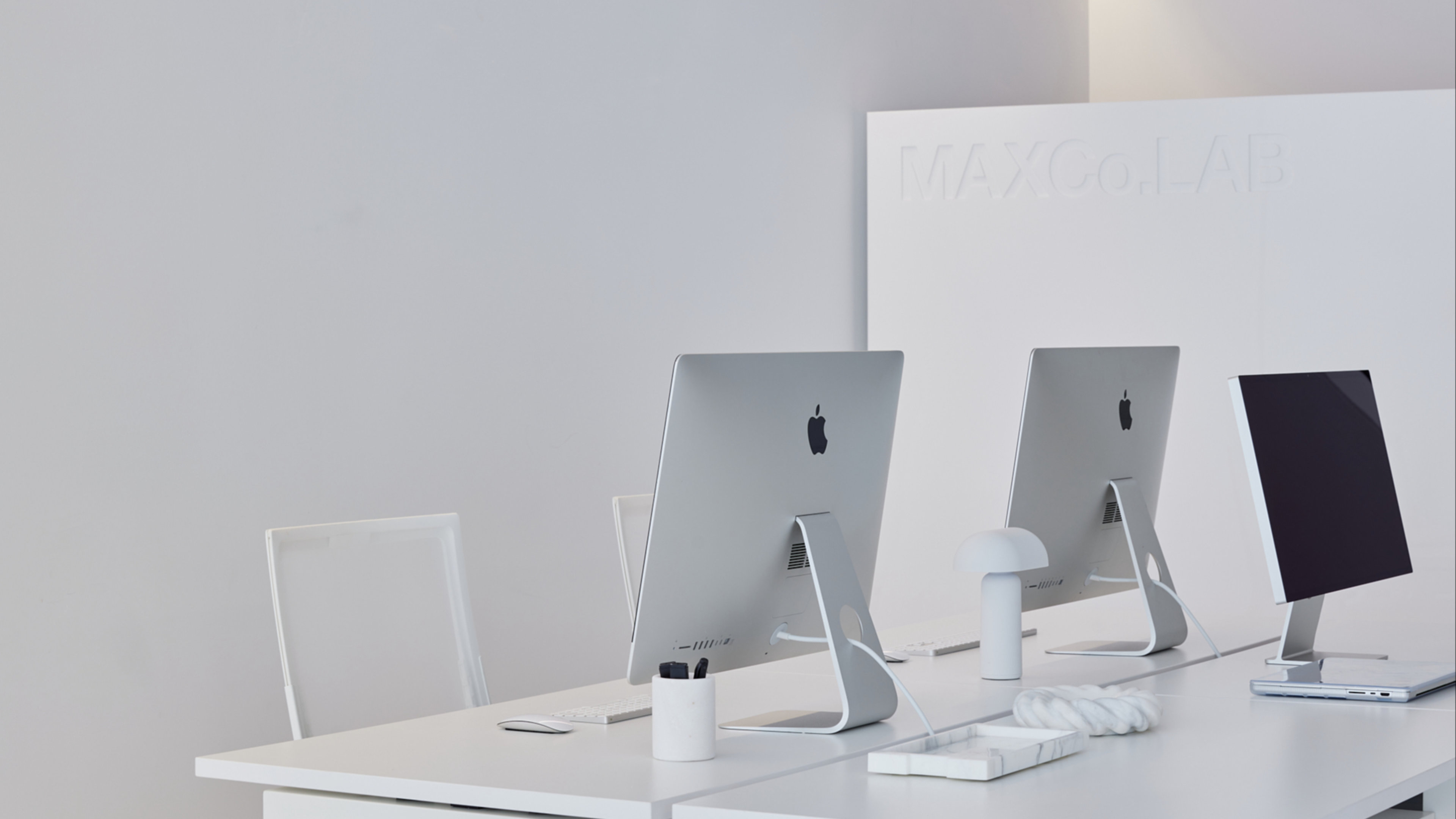 Desk with Apple computers in MAXCo.LAB office.