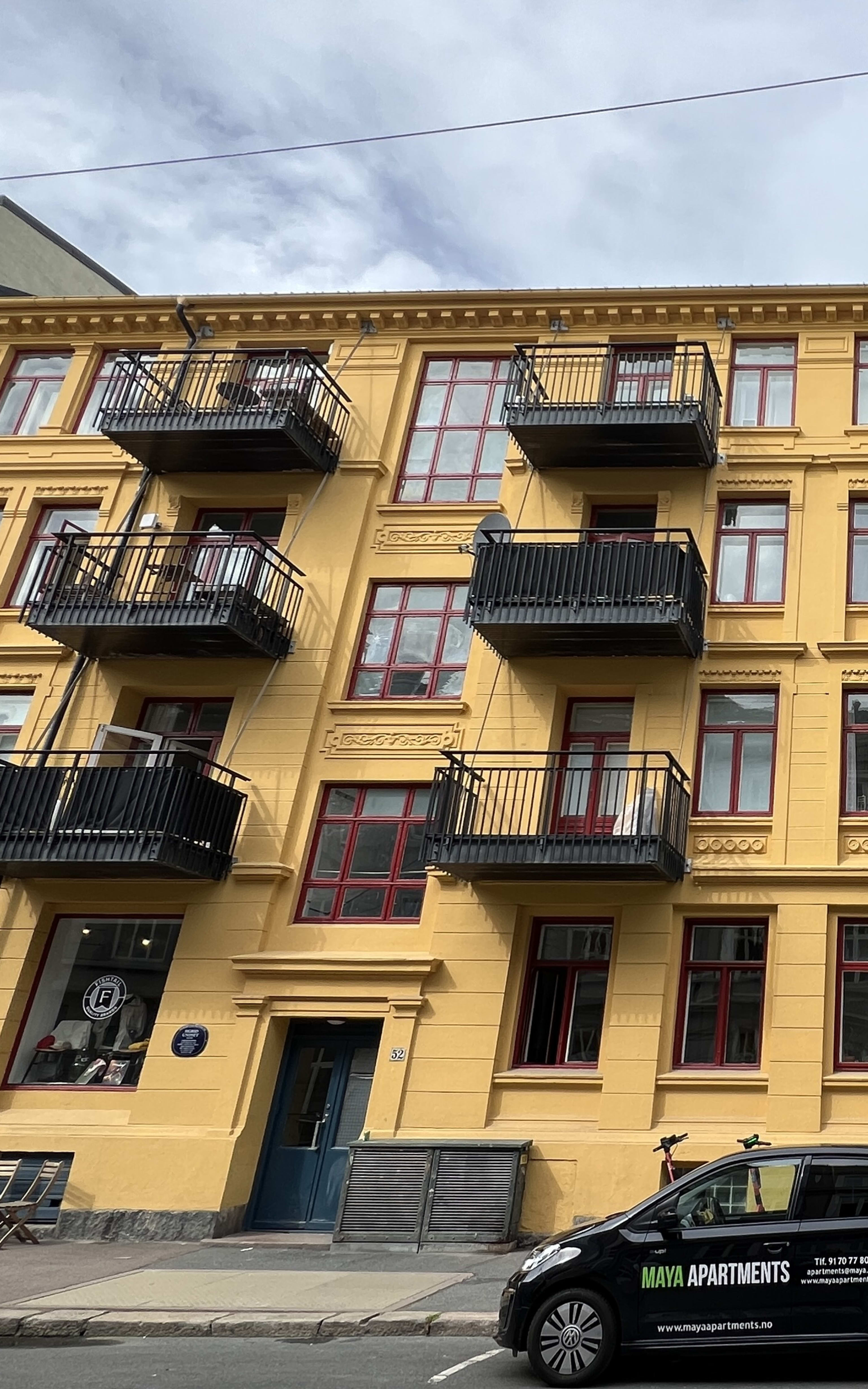 Fasade leiligheter med balkong forsiden fra gate med gateparkering utenfor