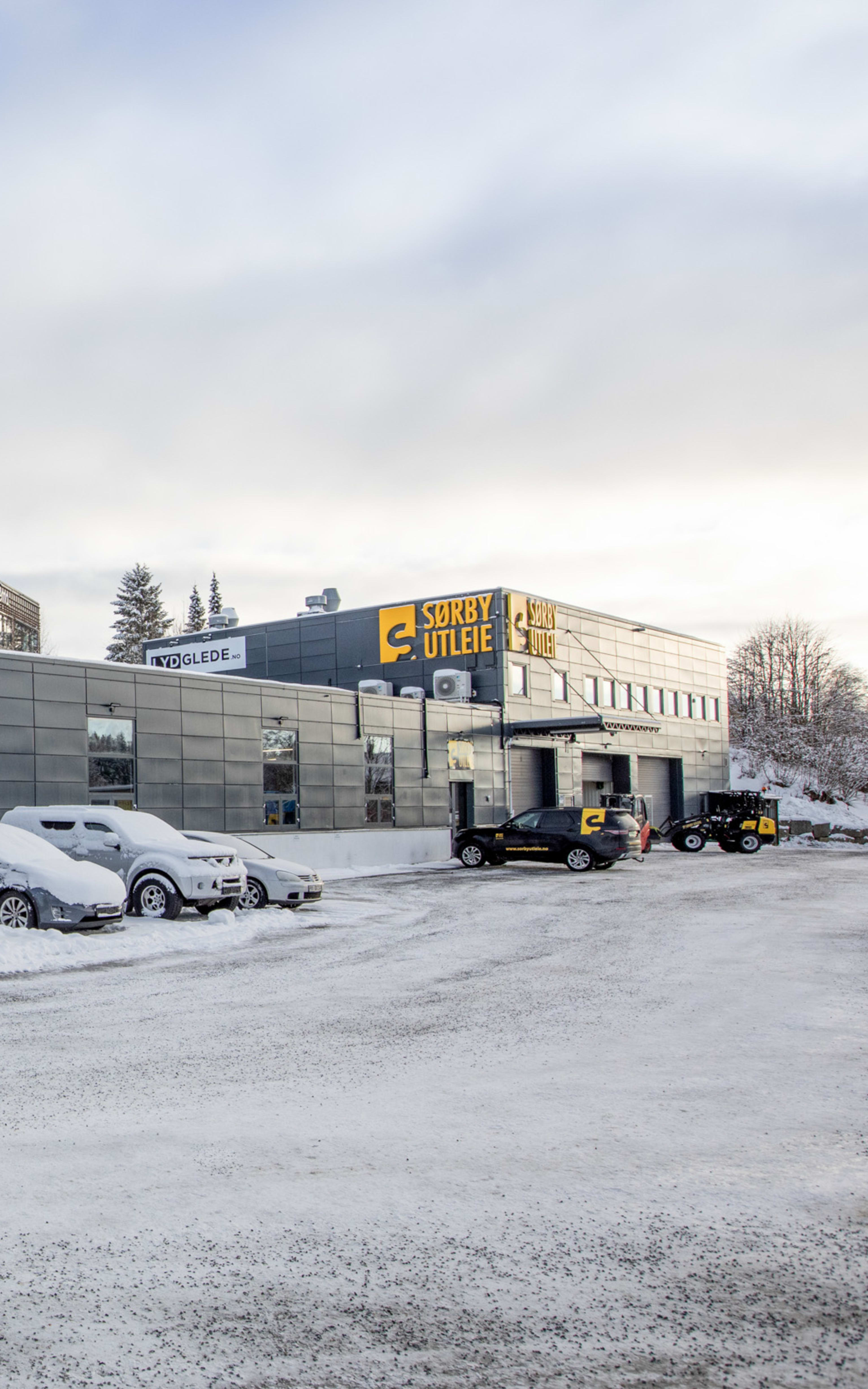 Vestby Næringspark fasade sett fra bakside på vinterstid med parkering utenfor