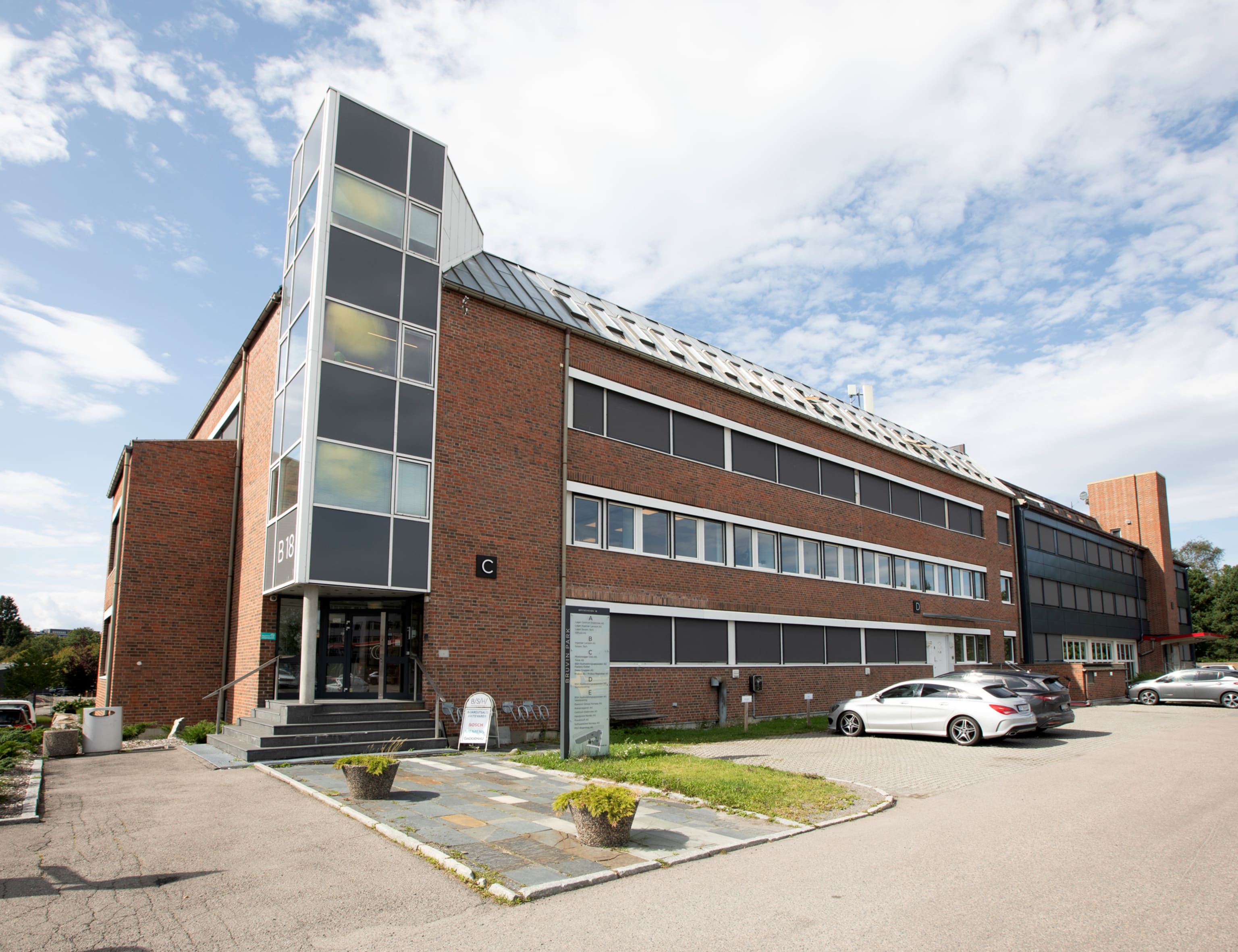 Brynsveien 18 fasade hovedinngang med parkering på utsiden