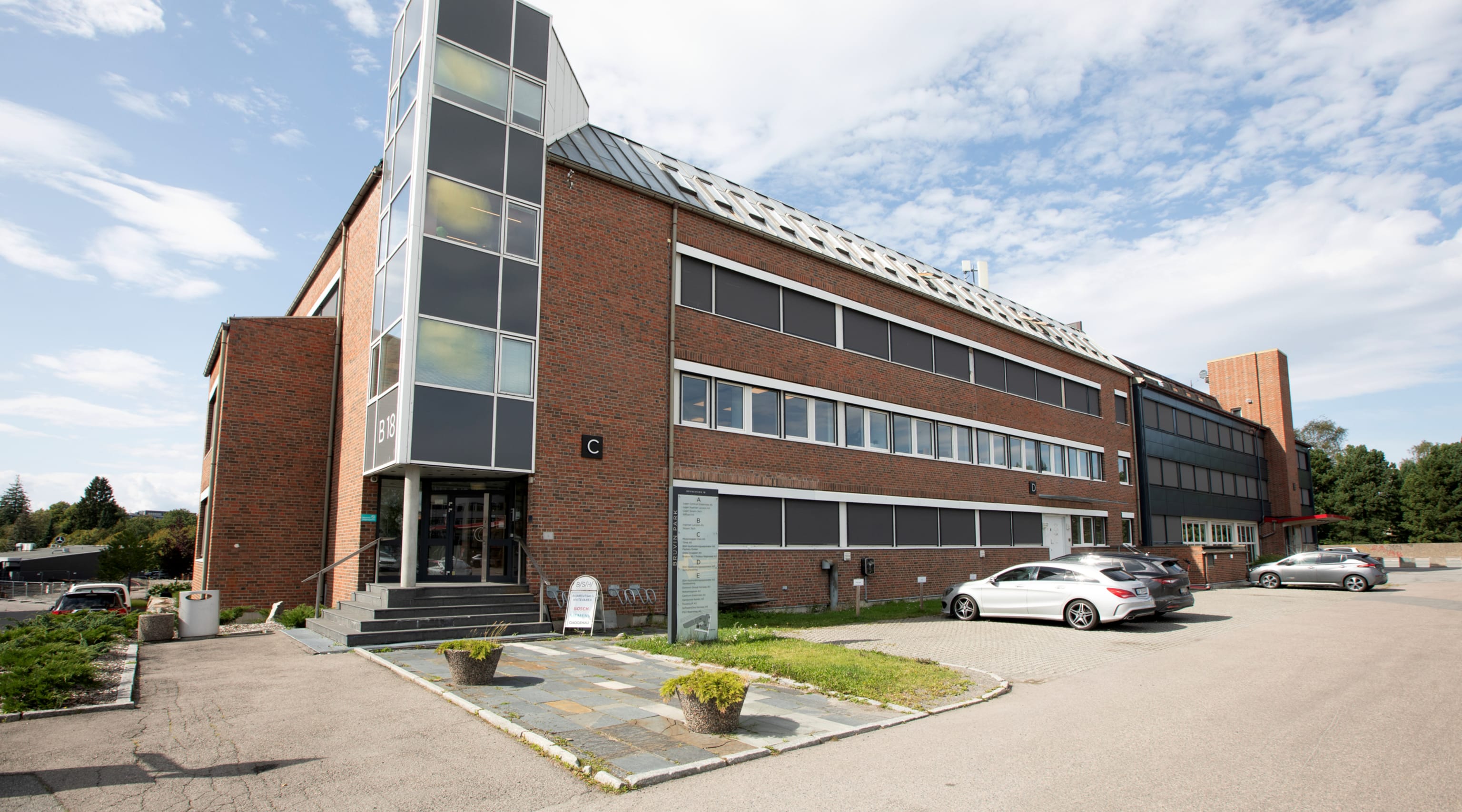 Brynsveien 18 fasade hovedinngang med parkering på utsiden