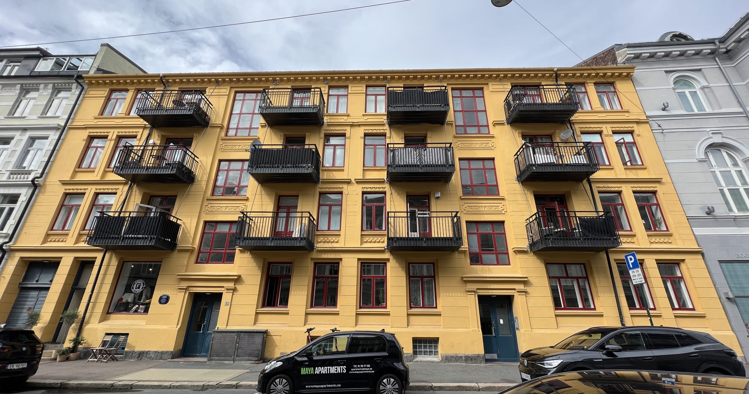 Fasade leiligheter med balkong forsiden fra gate med gateparkering utenfor