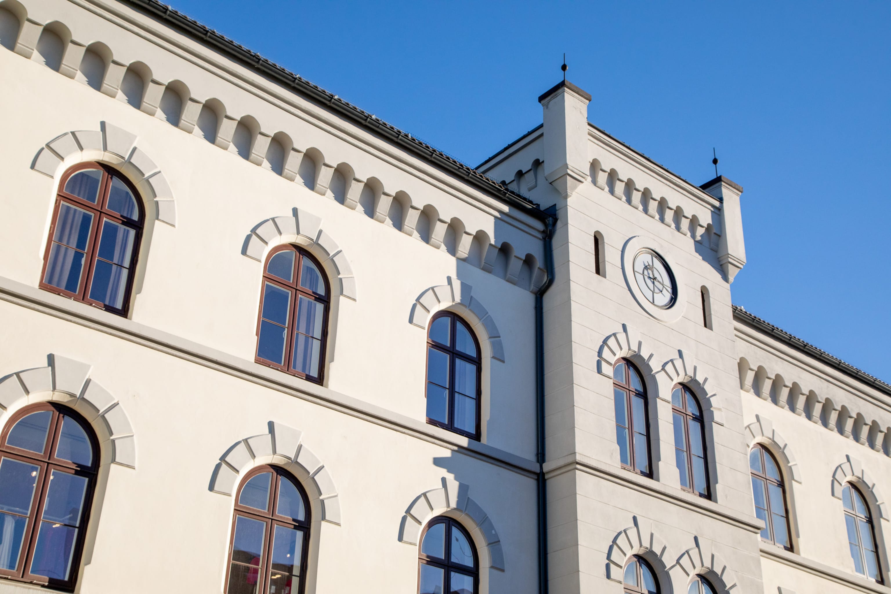 Fasade forsiden av leilighets-og næringsbygg med gammelt klokketårn