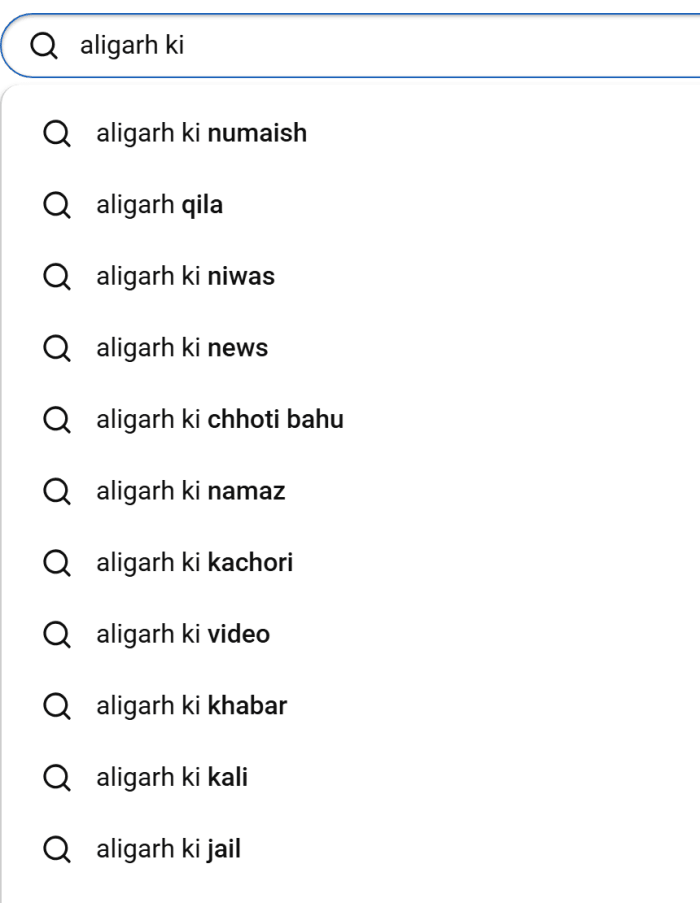 YouTube search box with "aligarh ki" typed and "aligarh ki numaish" as the first suggestion, followed by qila, niwas, news, kachori, video and khabar.