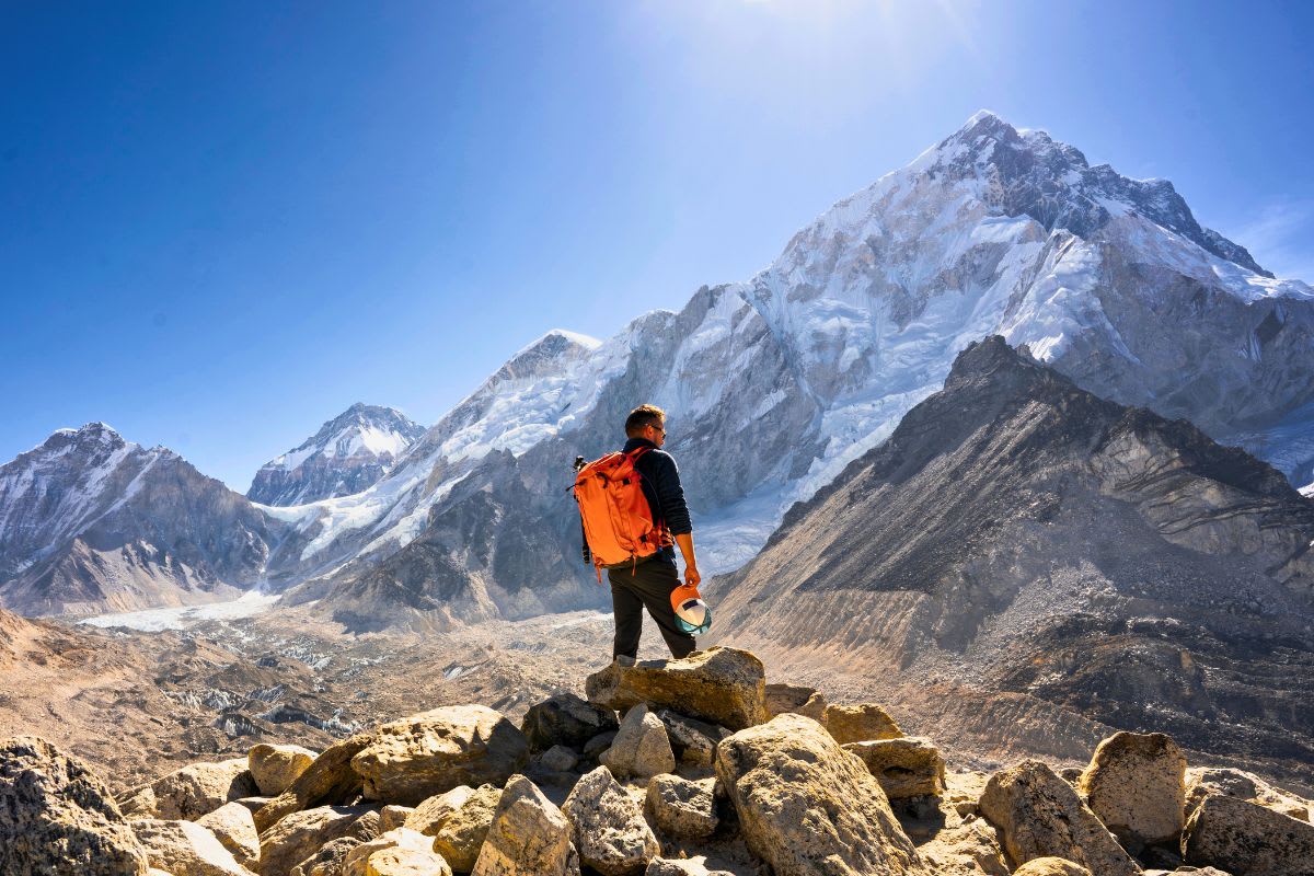 Trekker auf einem Steinhaufen unter dem Nuptse