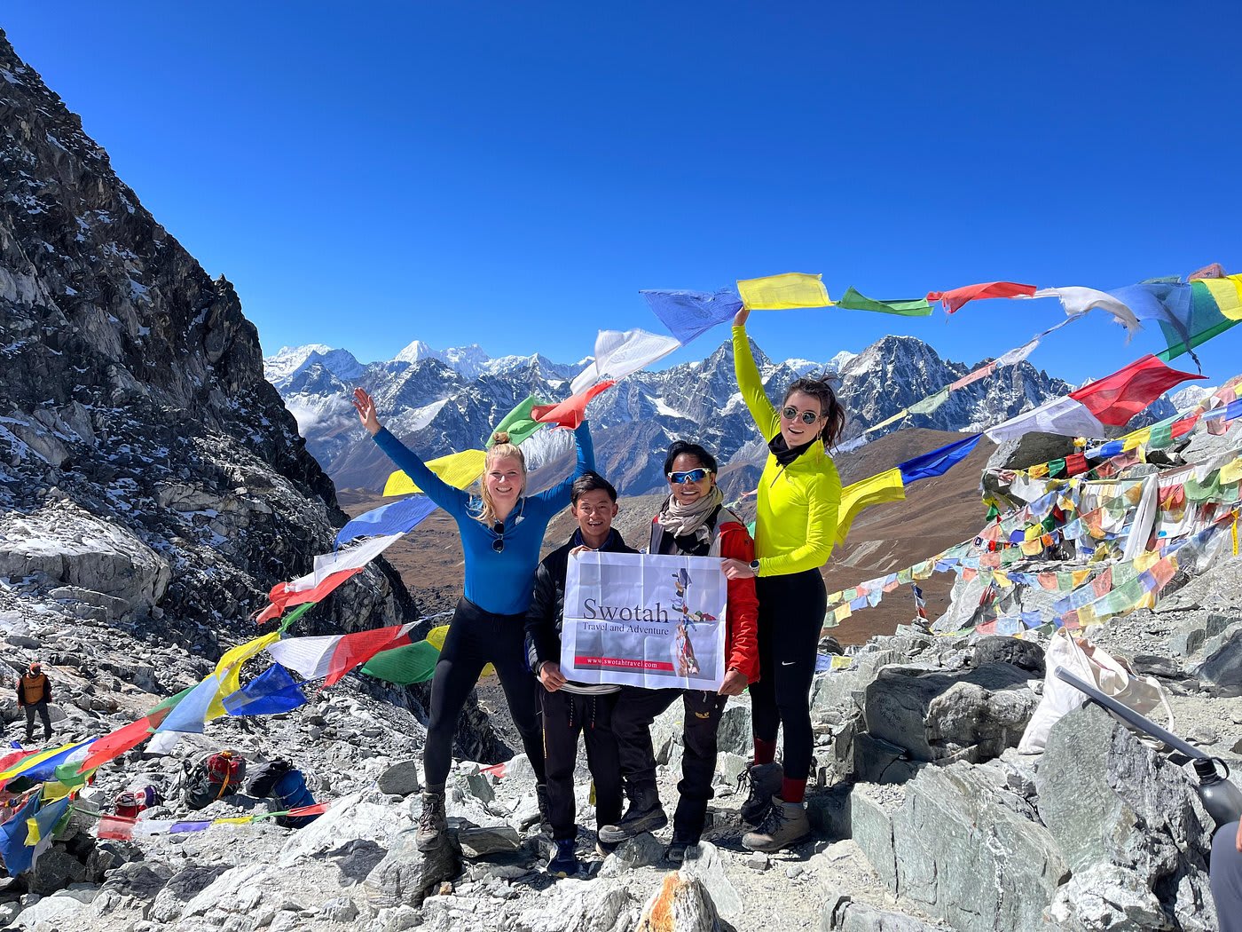 Trekkinggruppe zwischen Gebetsfahnen hoch über dem Gokyo-Tal