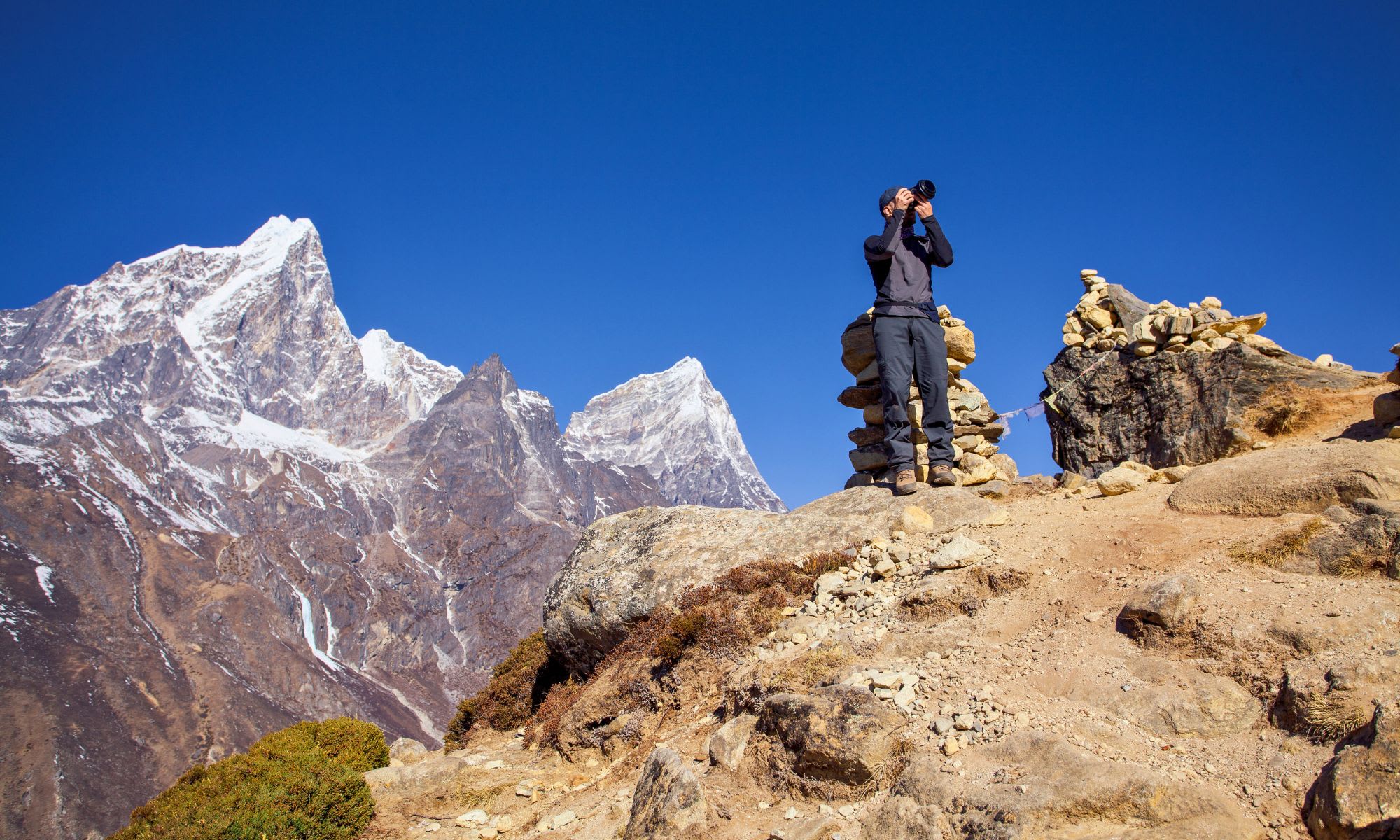 Trekker mit Fernglas vor Thamserku und Kangtega