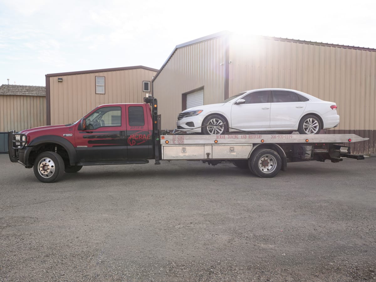 McRae Towing and Recovery flatbed with a car loaded for transport.