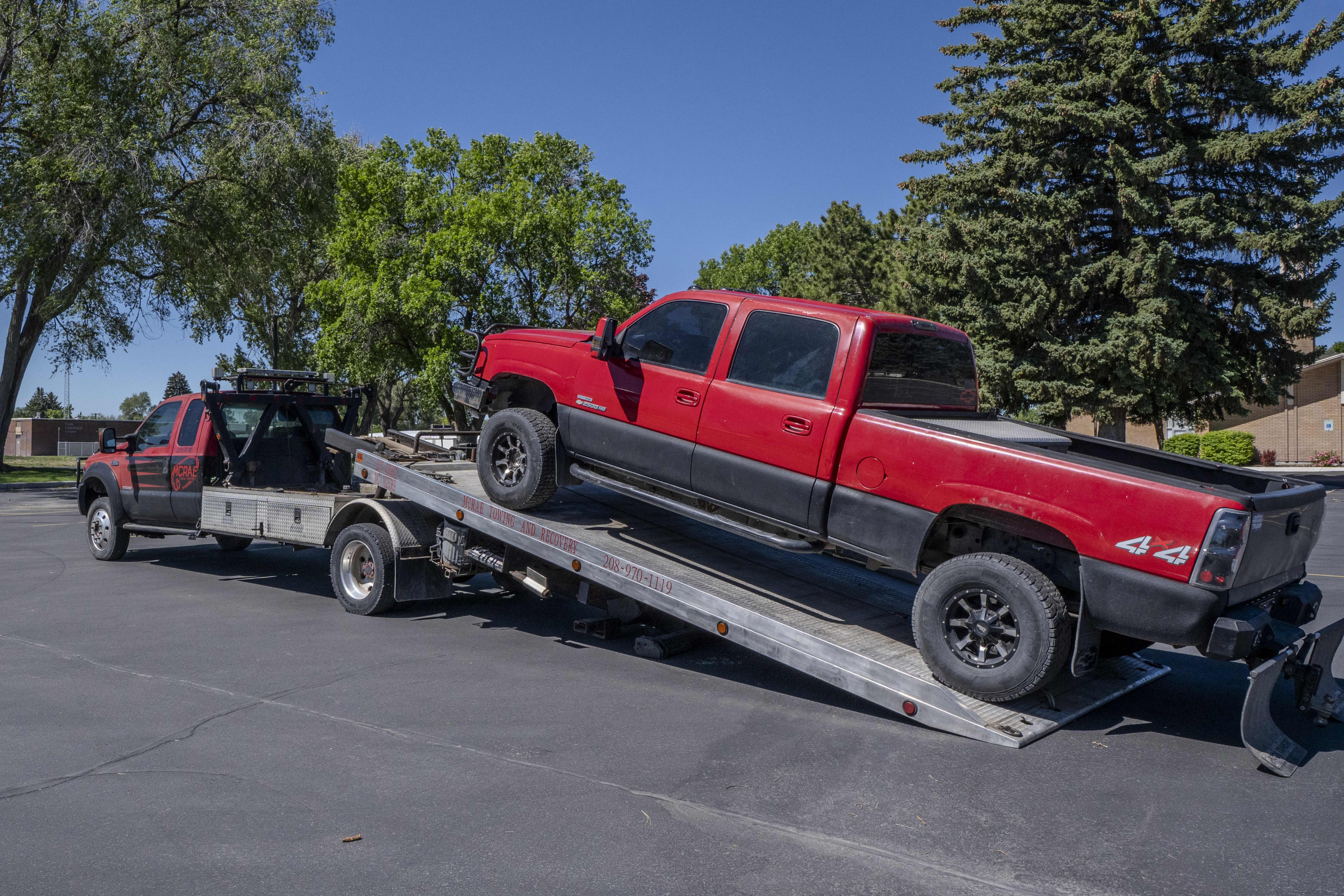 McRae Towing & Recovery flatbed loading a truck from a private parking lot for private property towing.