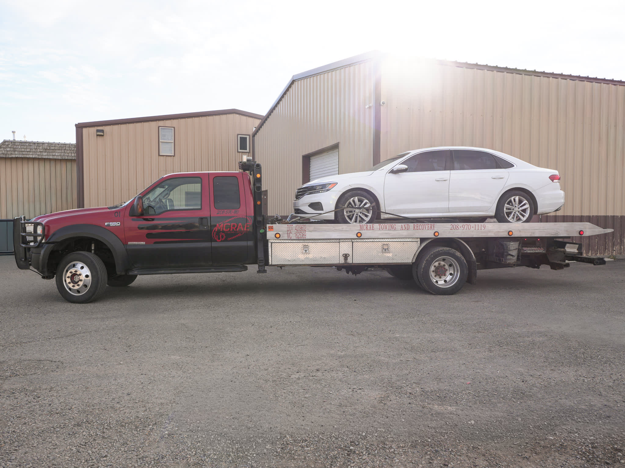 McRae Towing & Recovery flatbed with a car loaded for transport.