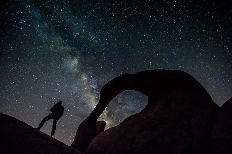 Sniper standing in front of a dark sky