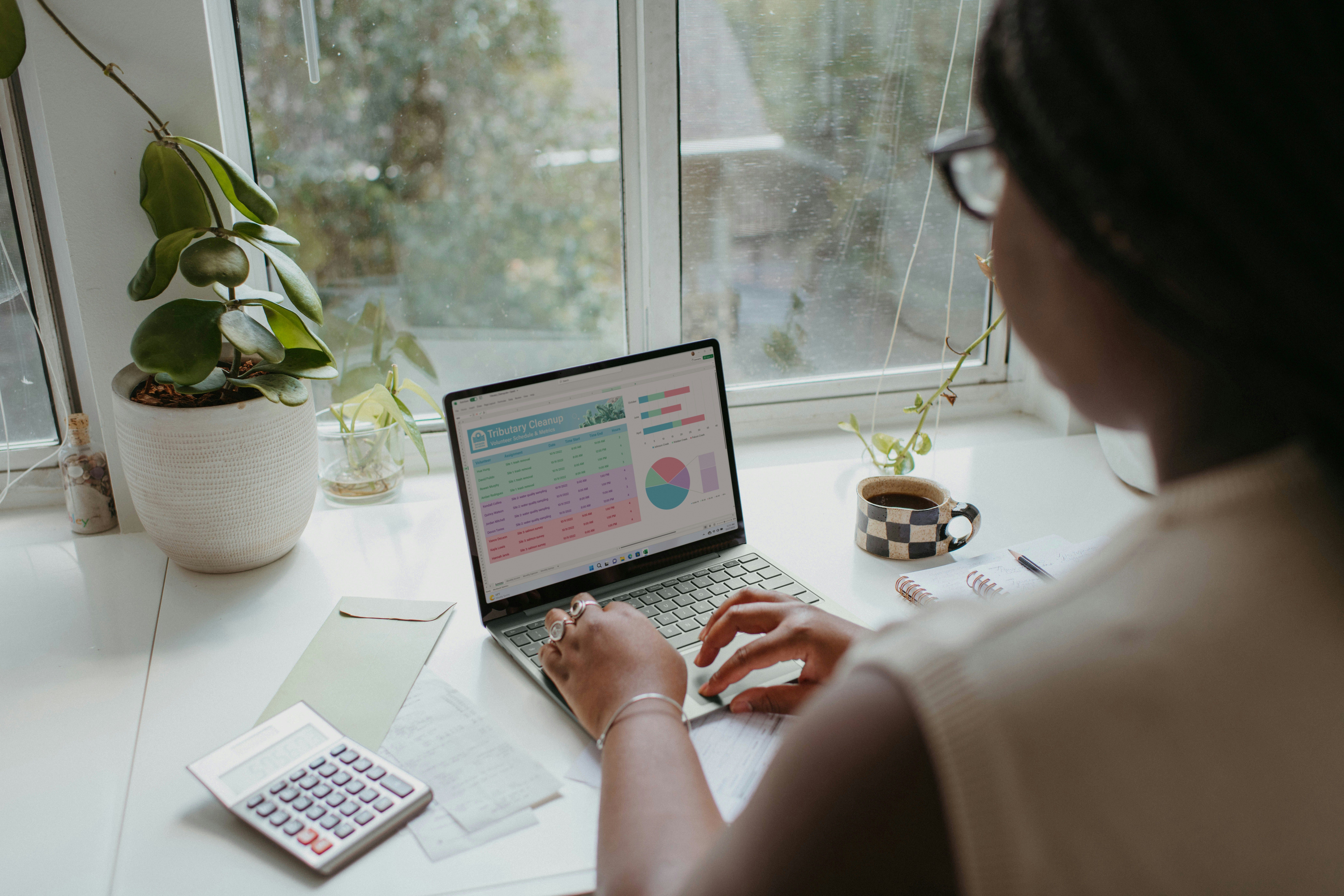 A person reviewing a budget spreadsheet with AI-generated spending categories on a laptop screen
