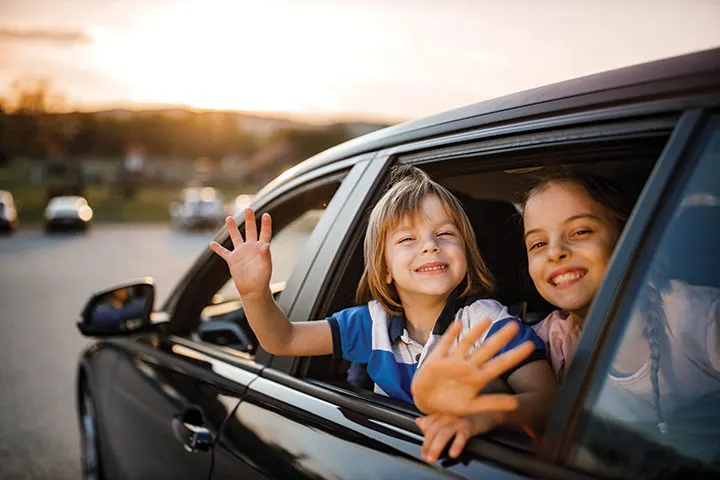 Girls waving out of car window