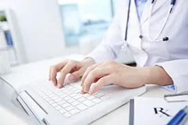 Doctor researching on laptop
