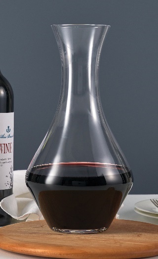 A glass decanter with dark liquidDescription automatically generated