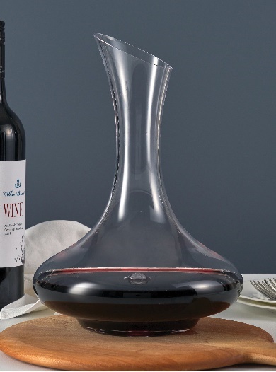 A glass decanter with a red liquid in itDescription automatically generated