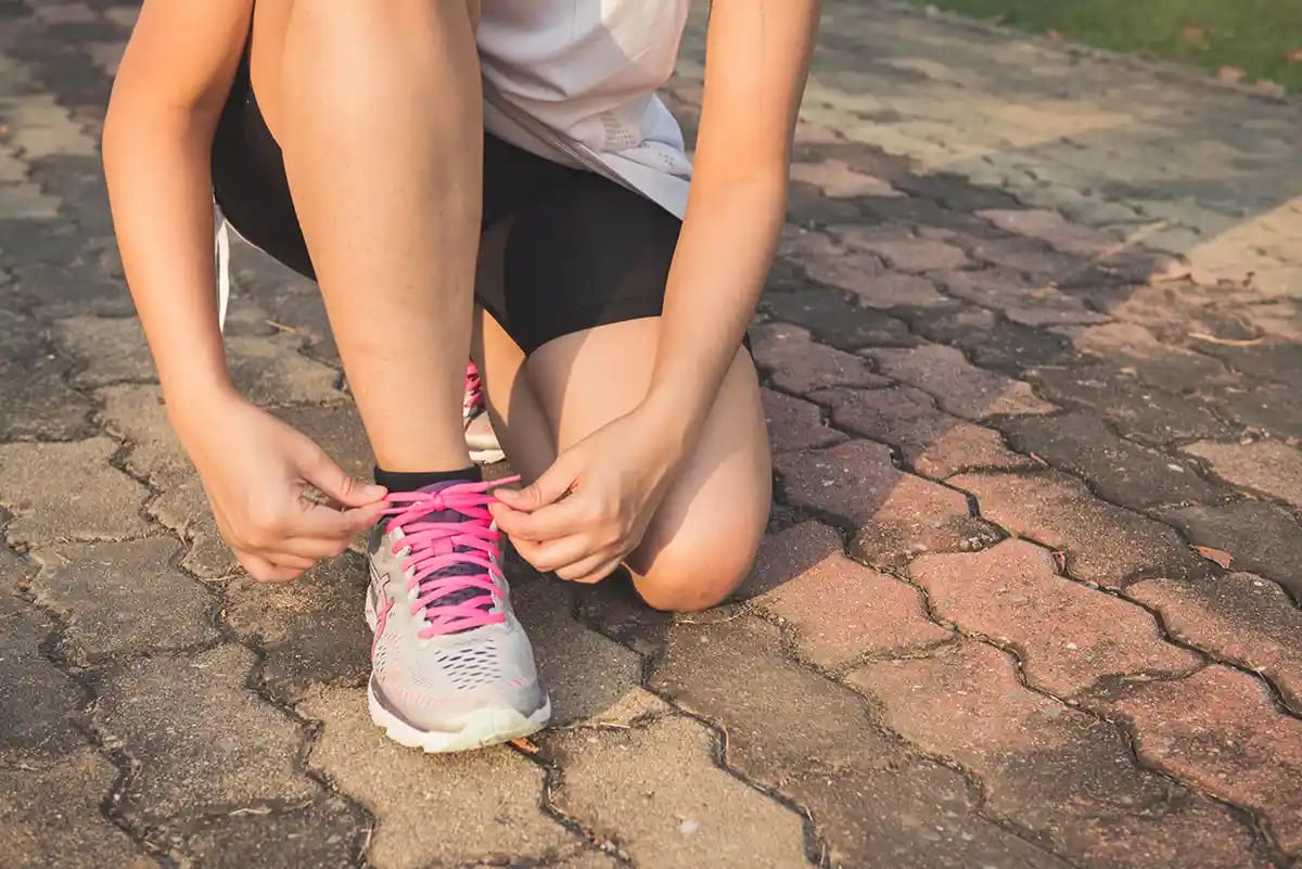 Woman putting on her running shoes