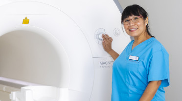 Woman clinician standing in front of MRI scanner