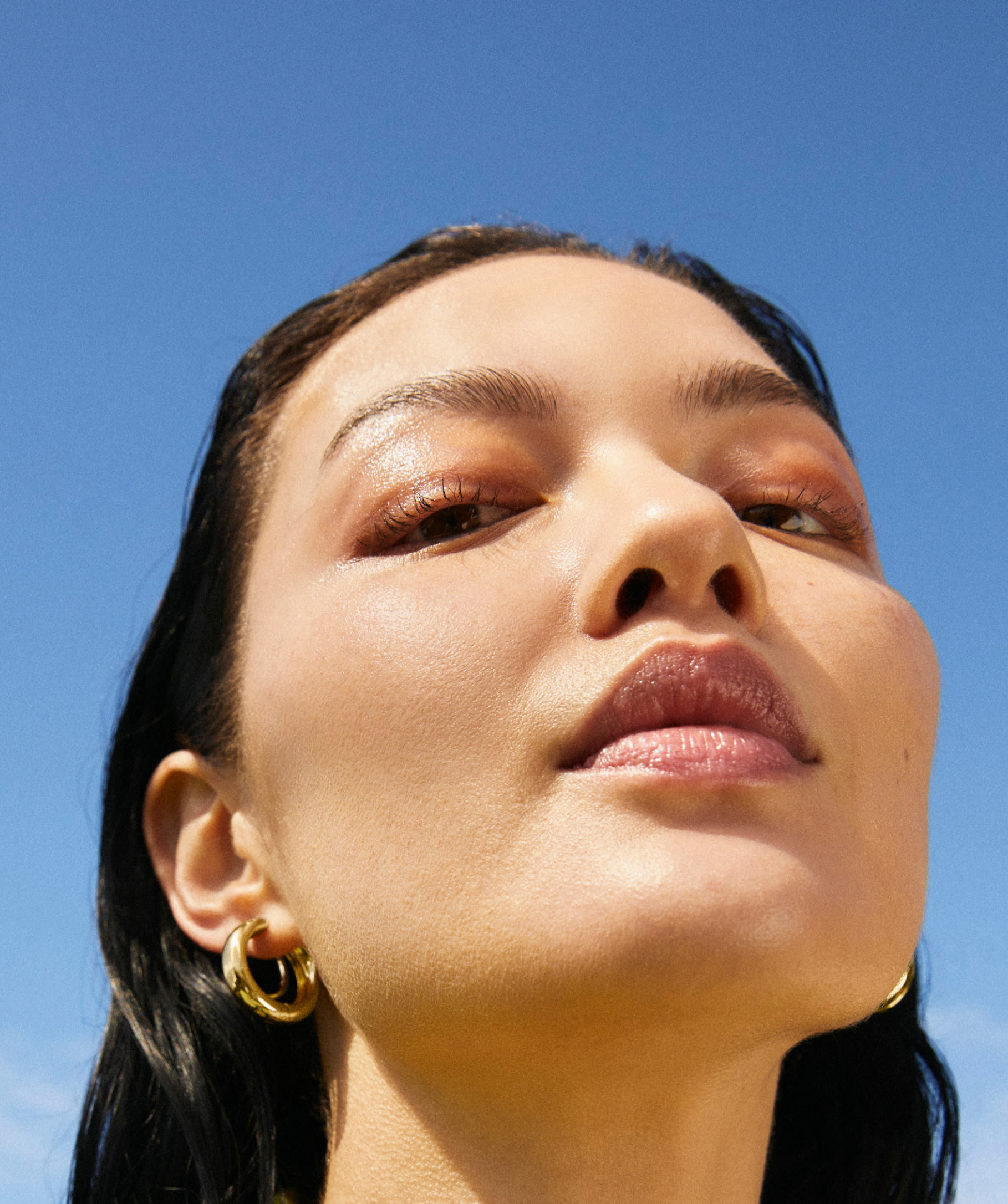 Model posing with Mejuri earrings. 