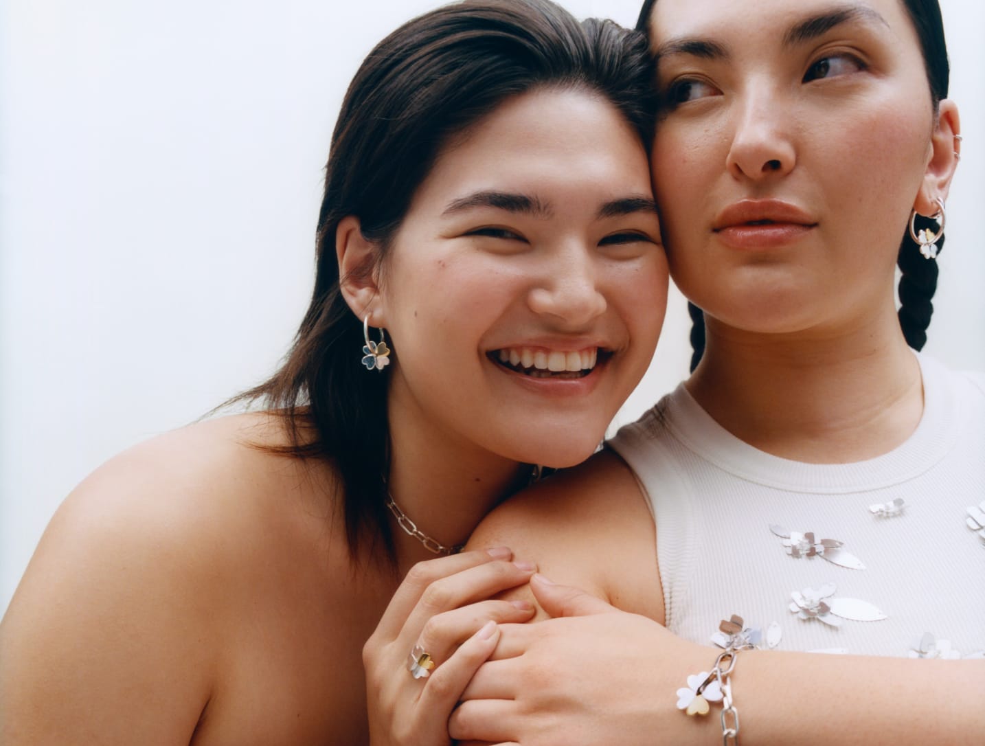 Yumi and Natalie are hugging each other. They are wearing all Mejuri X Ganni jewelry. 