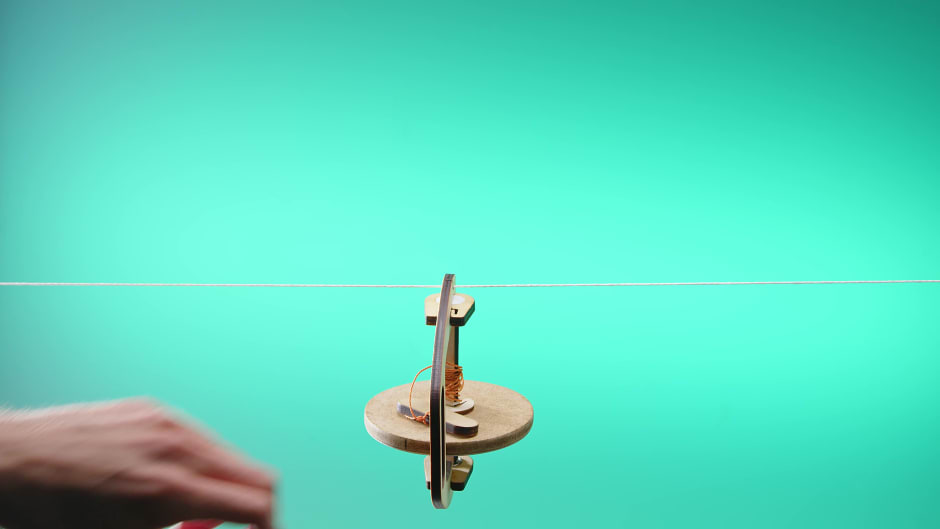 Gyroscope balancing on a wire - Stock Image - C026/6474 - Science