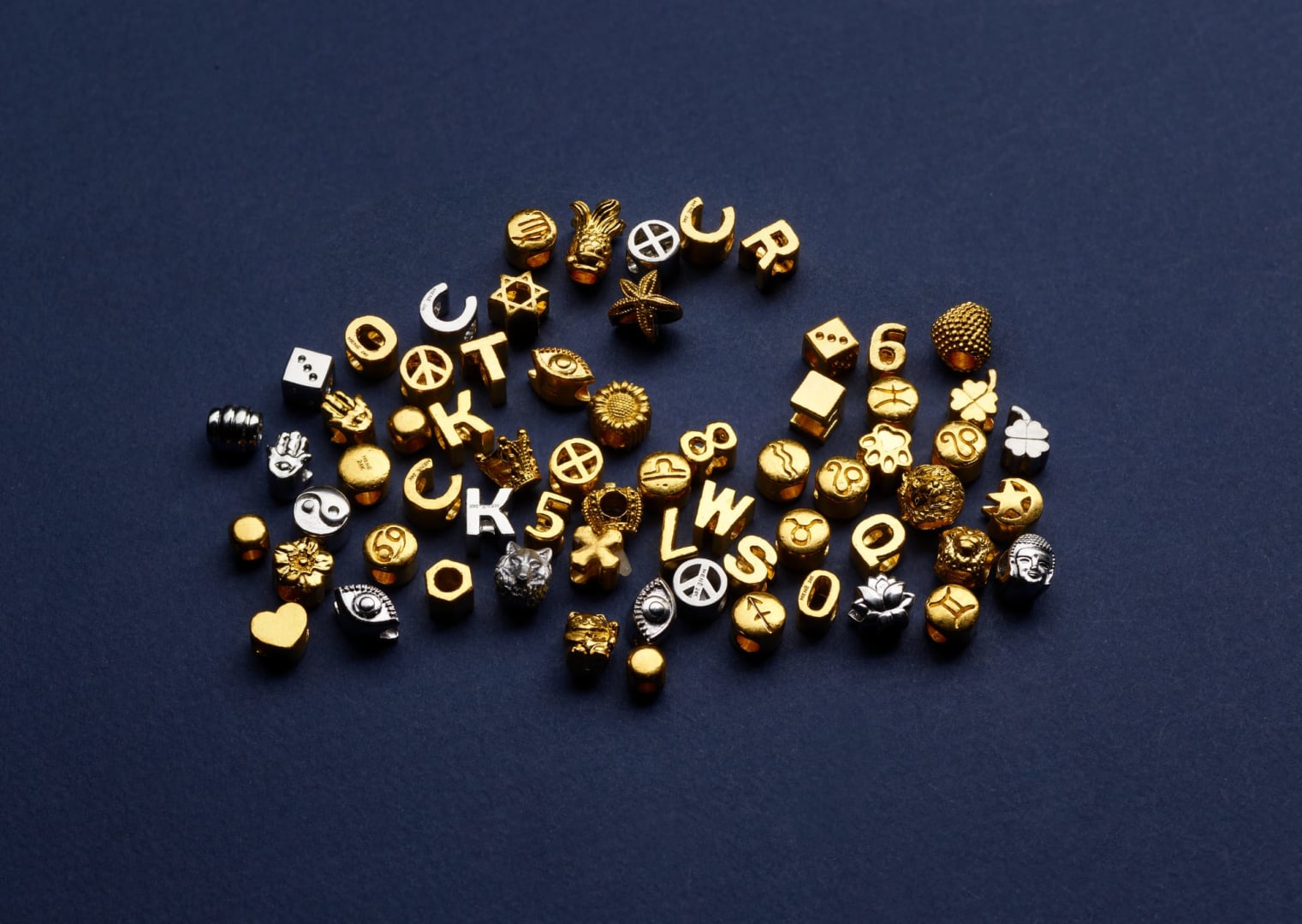 A selection of Menē Charms in 24k gold and pure platinum