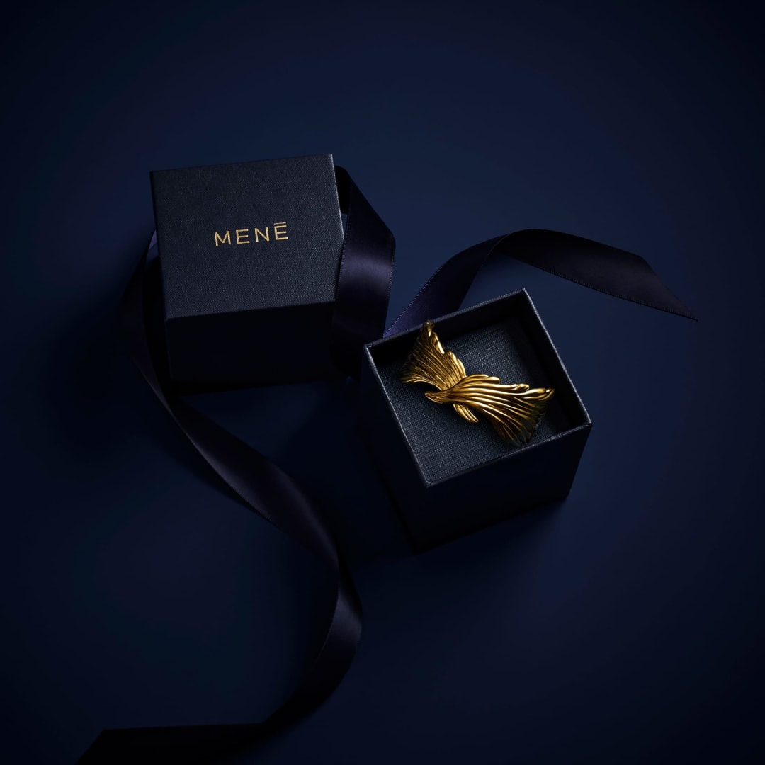 A Menē piece in 24k gold, showing the deep, consistent warmth of pure gold that does not tarnish or fade.