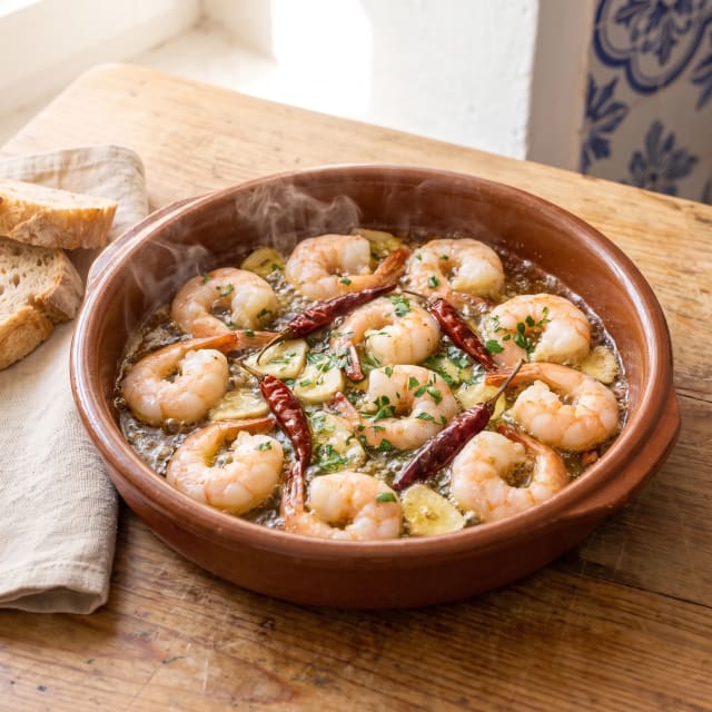 Gambas al ajillo en aceite que chisporrotea