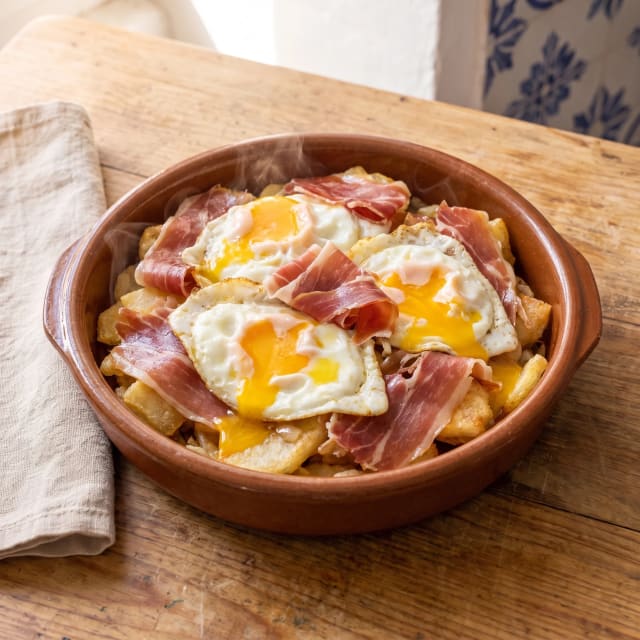 Huevos rotos con jamón y la yema líquida