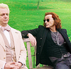 Good Omens Aziraphale sits on bench with long haired Crowley next to him
