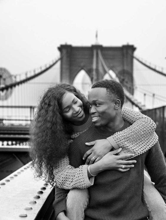 black couple smiling on the Brooklyn bridge 