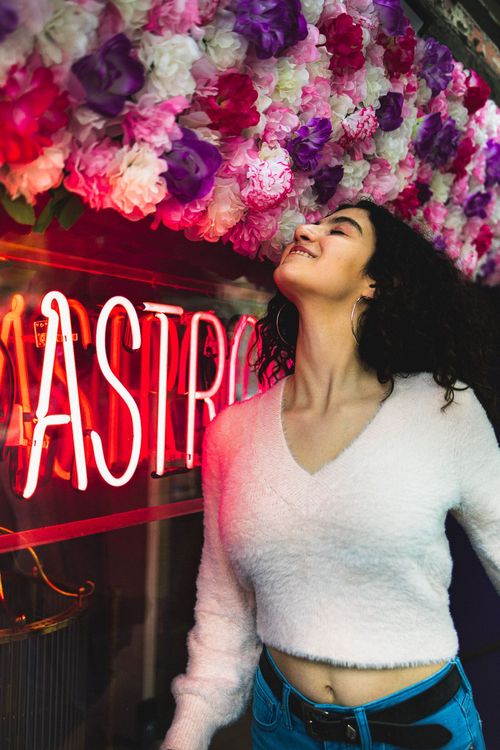 girl smelling pink flowers in soho New York city 