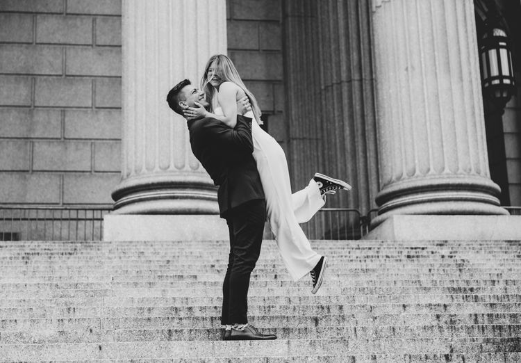 guy holding girl in city hall on the stairs New York City 