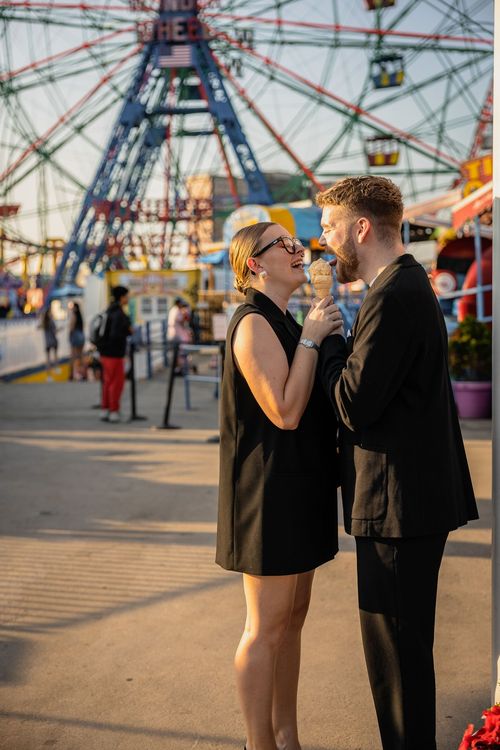 couple licking ice cream by the big carousel in Coney Island 