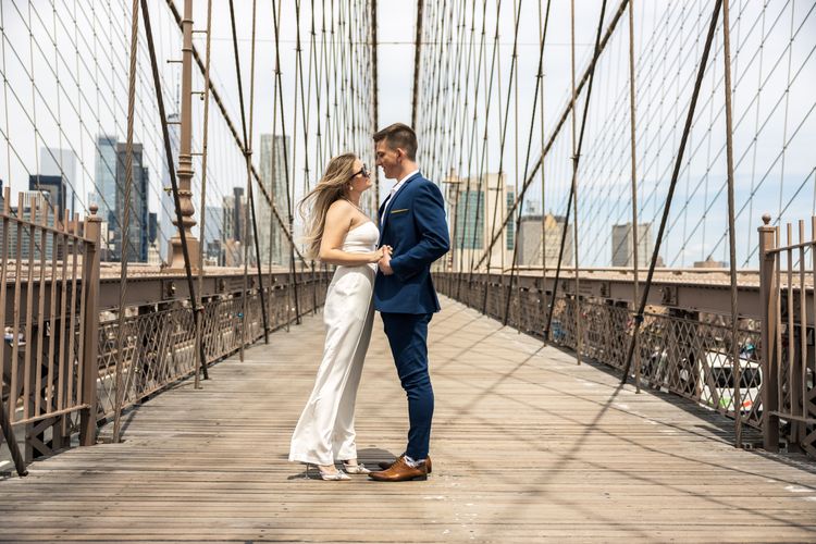 couple holding hands on Brooklyn Bridge