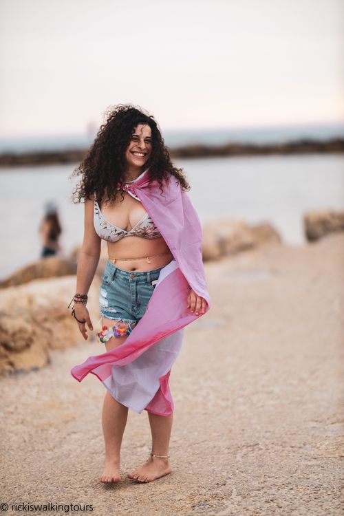 curly girl on the beach in Tel Aviv wearing pride flag 