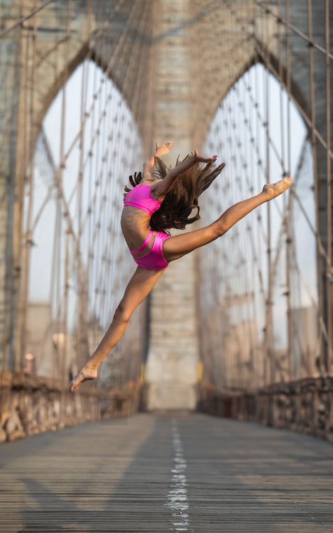 professional dancer on the Brooklyn bridge doing a split in the air 