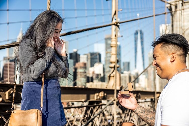 guy kneeing with big ring next to World Trade Center in Brooklyn Bridge 