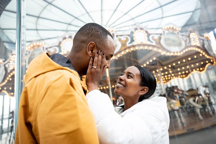 couple taking a picture by janes carousal in dumbo Brooklyn 