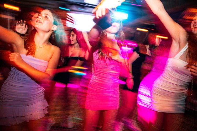 girls dancing at a party with flashing lights long exposure 