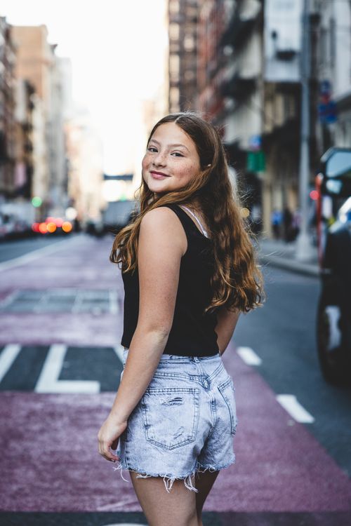 girl in short jeans in soho with freckles & long red  hair 