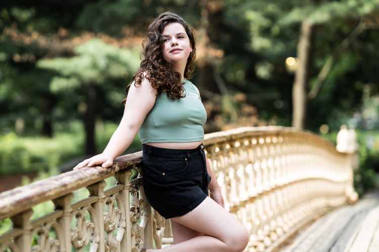 girl standing on the bow bridge in Central Park by the bethesda fountain 