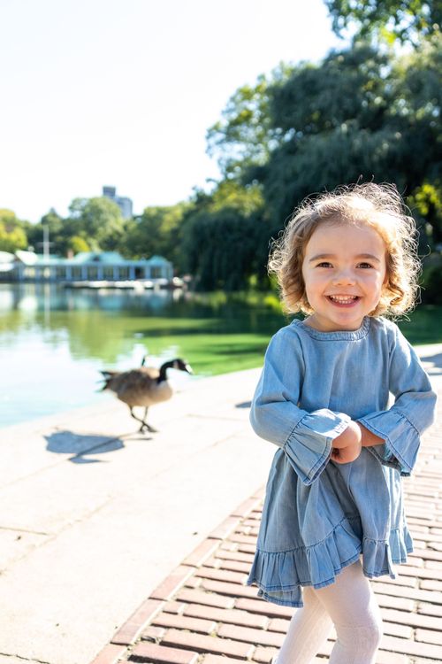 girl standing on the bow bridge  in Central Park by the bethesda fountain