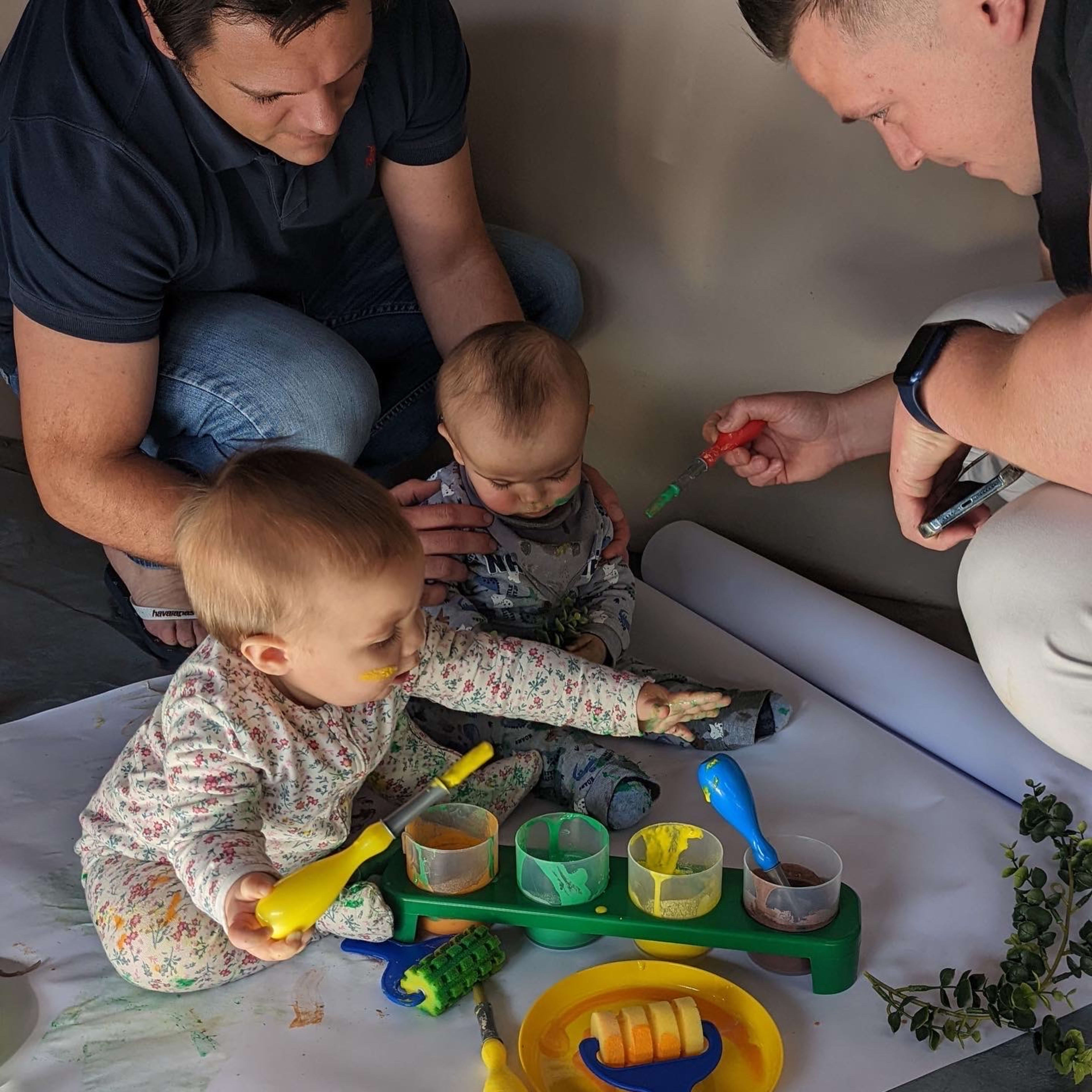 Dads painting with their babies.