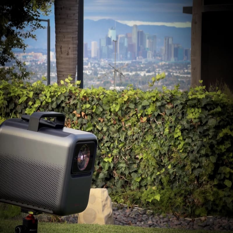 Outdoor projector overlooking a city skyline beyond the garden