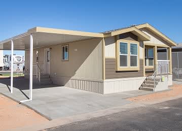 Exterior view of a manufactured home with a front porch at Cotton Lane RV Resort.